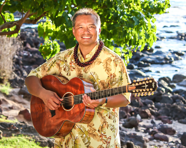 Larry with guitar along the shore